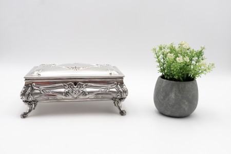 Guarda jóias em prata com alto relevo na tampa e envolvência, quatro pés curvos 